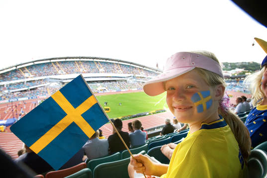 Flicka med svensk flagga på läktaren. Supporter, Sverige,