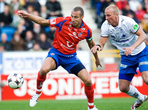 Henrik Larsson tar ner bollen och håller undan Thomas