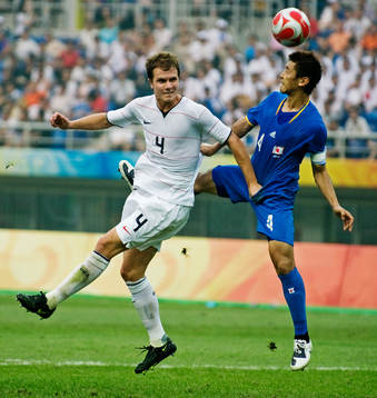 Michael Bradley, USA, tar skamgrepp på Hiroki Mizumoto,
