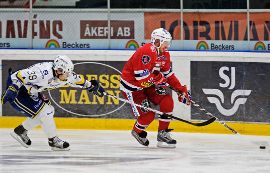 Jukka Voutilainen, HV71, försöker få tag i Jens Olsson,