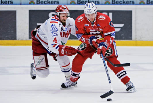 Robin Jonsson, Timrå, försöker ta pucken av Linus