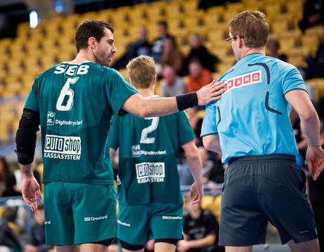 Domaren får klapp på axeln av spelare