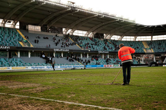 Gamla Ullevi, gräsmatta. Funktionär krattar. Dålig plan