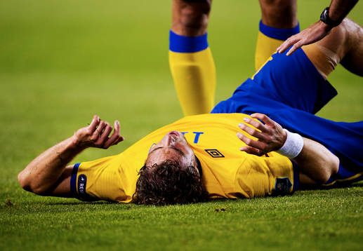 Johan Elmander, Sverige, ligger och vrider sig i plågor.