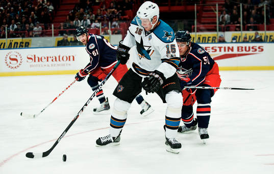 Dany Heatley, San Jose, håller undan pucken från Antoine