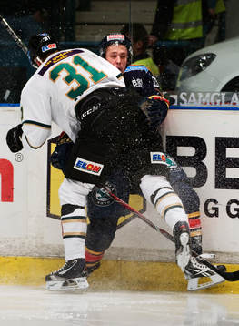 Dick Axelsson, Färjestad, tacklar Fredrik Claesson,