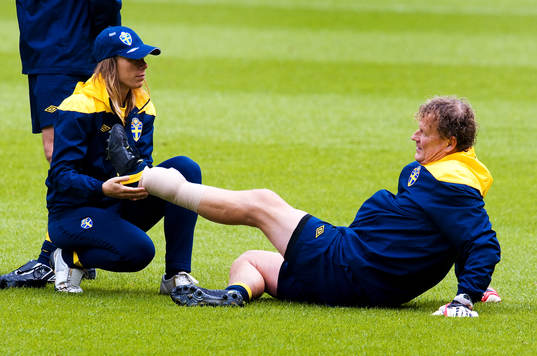 Karin Schröder, sjukgymnast plåstrar om Mikael Olsson,