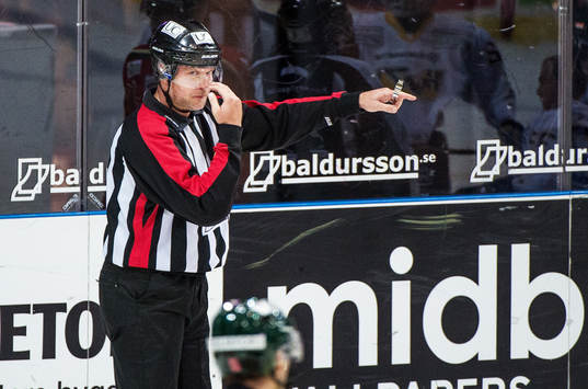 Domare Ulf Rönnmark, pekar mot mål och tecknar att han