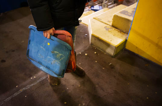 En flicka står och håller i två delar från stolar på