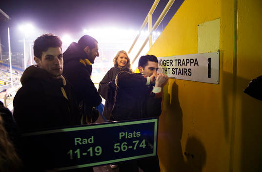 En grupp unga människor tar ner skyltar från Råsunda