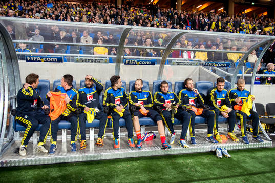 Spelarna sitter på bänken innan matchen