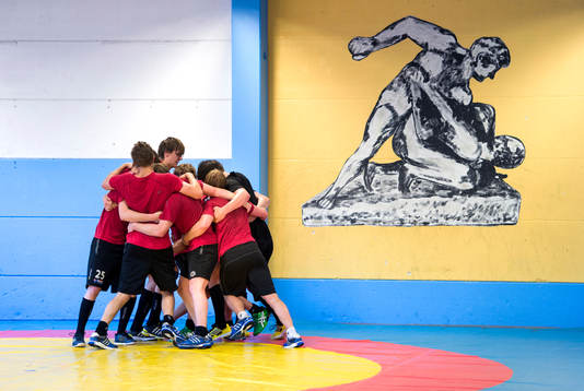 Spelarna bildar en ring runt en av lagkamraterna som ska