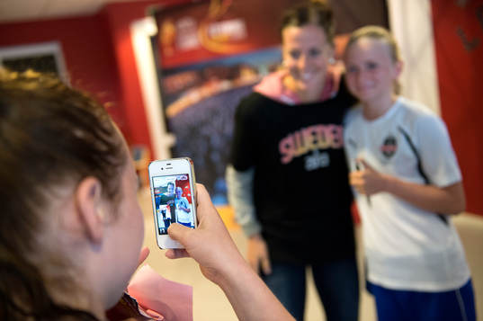 Lotta Schelin blir fotograferad med en av tjejerna