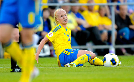 Sveriges Caroline Seger sitter på gräset och deppar i