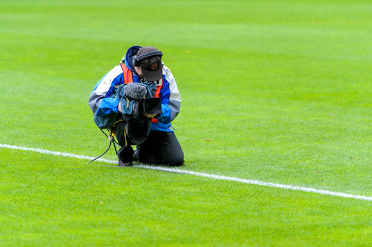 Tv-fotograf på planen innan fotbollsmatchen i allsvenskan