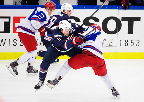 s Riley Barber tacklas av Rysslands Ilya Lyubushkin