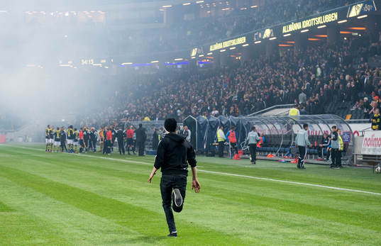 En AIK supporter springer in på planen