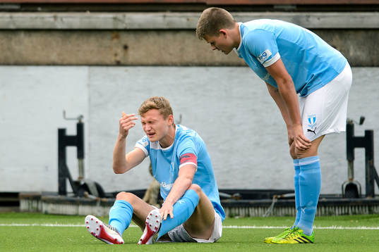 Malmös Piotr Johansson sitter skadad i gräset