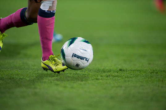 Fotbollsskor Nike och fotboll Hummel i matchen i