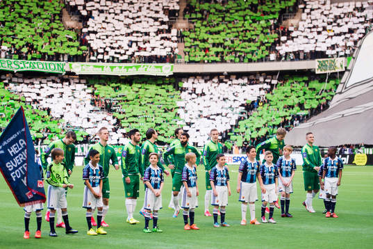 Hammarbys spelare står uppställda framför supportrarnas