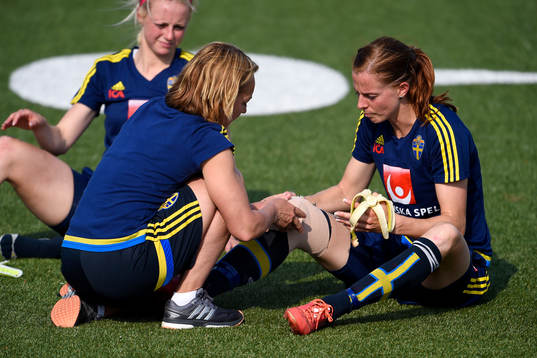 Sveriges Lotta Schelin får sitt knä lindat av Sjukgymnast