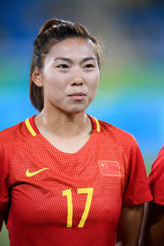 Kinas Yasha Gu vid lineup innan fotbollsmatchen mellan
