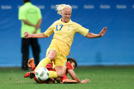 Sveriges Caroline Seger glidtacklas av en kinesisk spelare