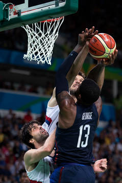 Två serbiska spelare försvarar mot USAs Paul George i