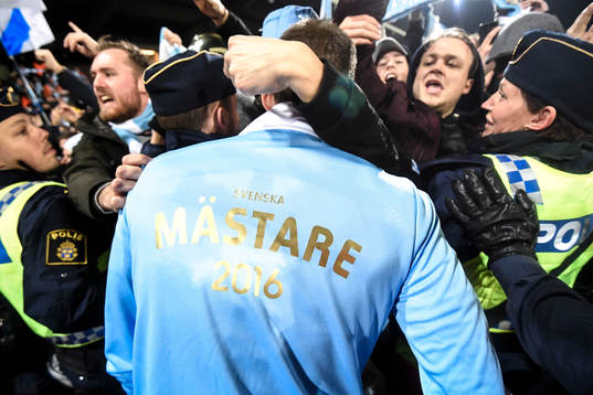 Spelare med segertröja jublar med supportrar