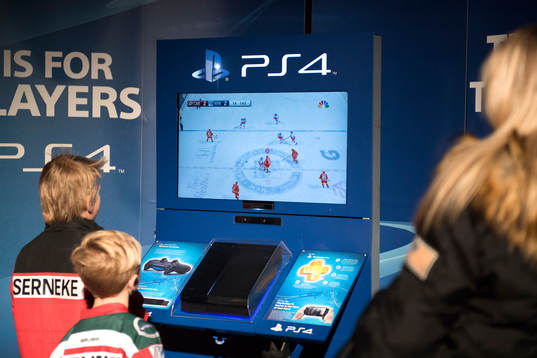 Två ungdomar spelar tv-spel innan ishockeymatchen i SHL