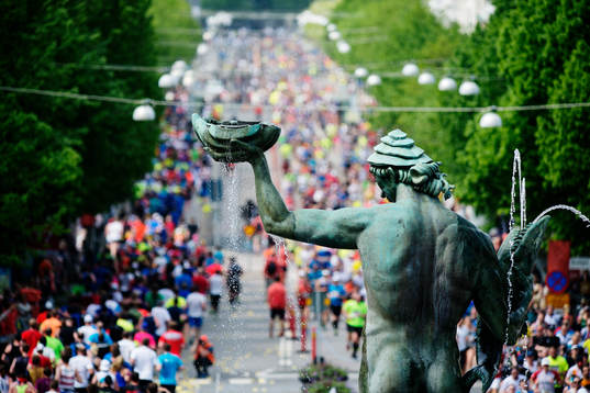 Statyn Poseidon med löpare i bakgrunden