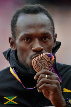 Jamaicas Usain Bolt kysser sin bronsmedalj vid