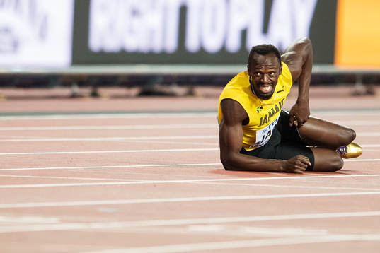 Jamaicas Usain Bolt ligger ner på banan skadad i finalen