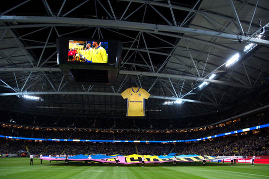 En sverigetröja hänger i taket på Friends Arena innan