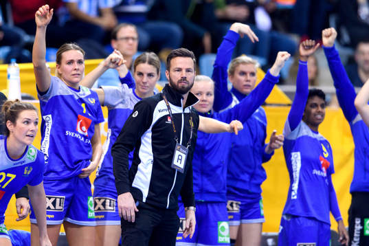 De svenska spelarna jublar på bänken bakom