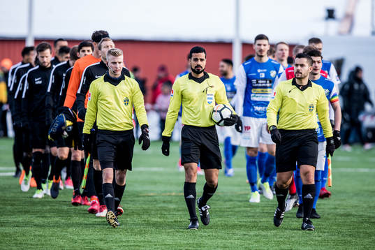 Domare Mohammed Al-Hakim leder in lagen till avspark