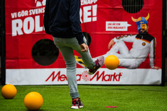En kille skjuter boll i Media Markts monter i fnazone