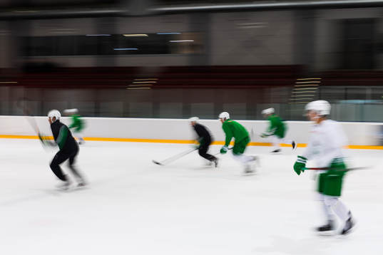 Panorering på spelare som åker skridskor på en träning