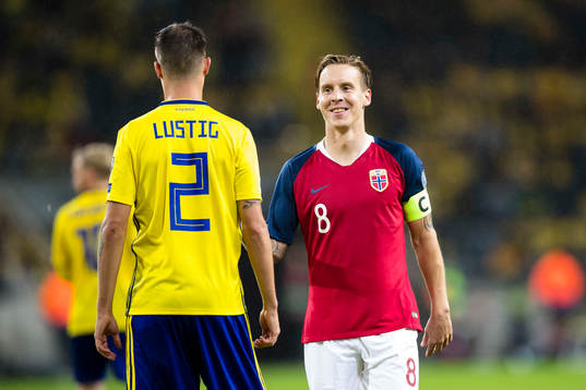 Stefan Johansen of Norway smiles with Mikael Lustig of