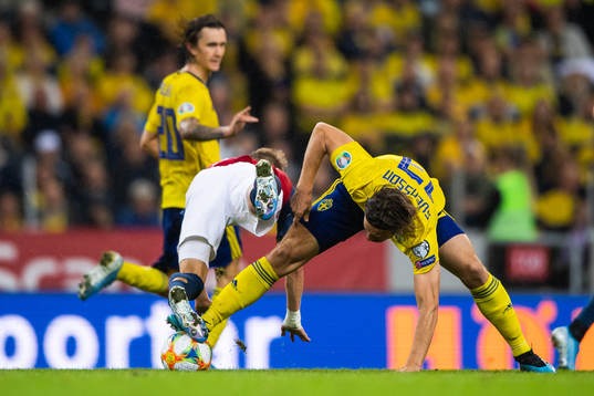 Martin Ødegaard of Norway falls over Gustav Svensson of