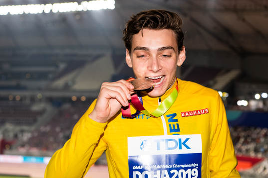 Armand Duplantis of Sweden bites his silver medal at the