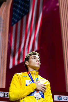 Armand Duplantis of Sweden (silver) holds a hand over his