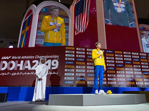Armand Duplantis of Sweden (silver) holds a hand over his