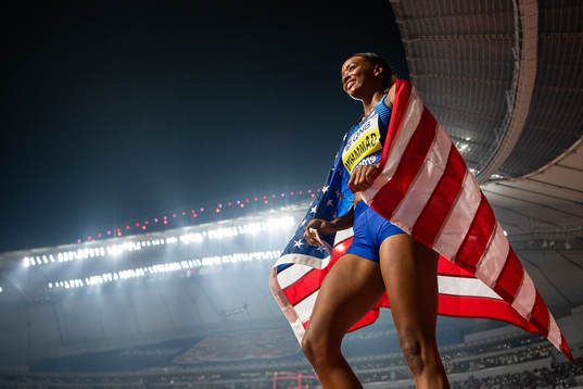 Dalilah Muhammad of USA celebrates with the American flag