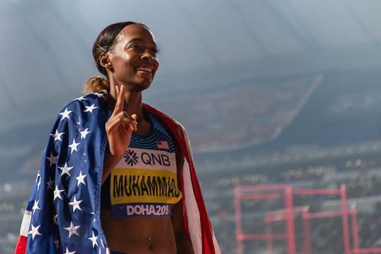 Dalilah Muhammad of USA celebrates with the American flag