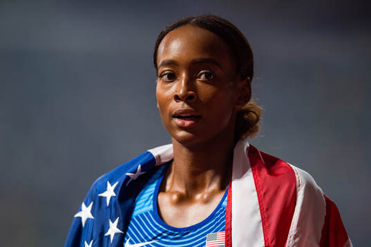 Dalilah Muhammad of USA celebrates with the American flag