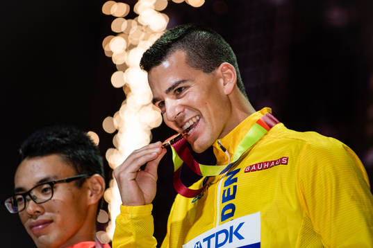 Perseus Karlström of Sweden bites his bronze medal at the