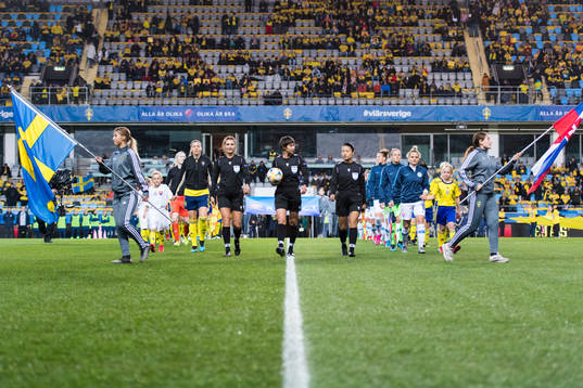 Referee Elvira Nurmustafina walks into the pitch together