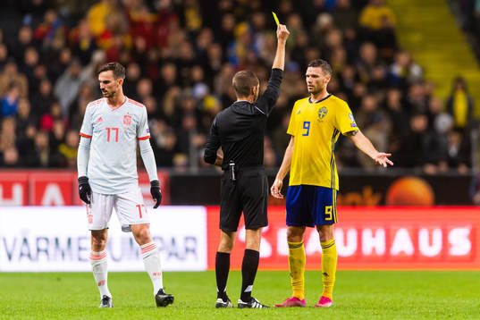 Marcus Berg of Sweden receives a yellow card from referee