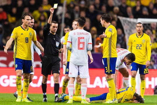 Dani Ceballos of Spain receives a yellow card from referee
